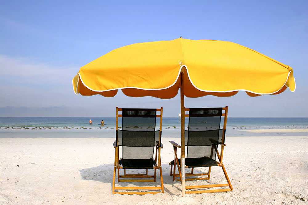 Chairs under a beach umbrella.